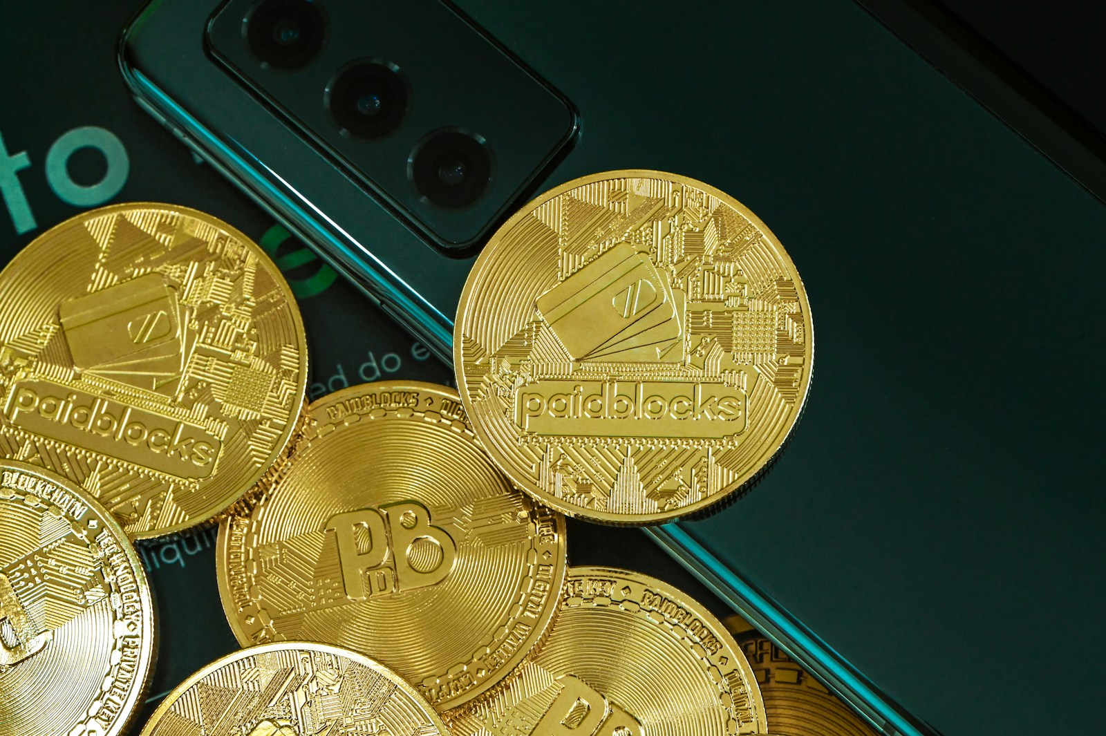 a pile of gold coins next to a cell phone